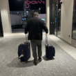 a man pulling luggage in a hallway