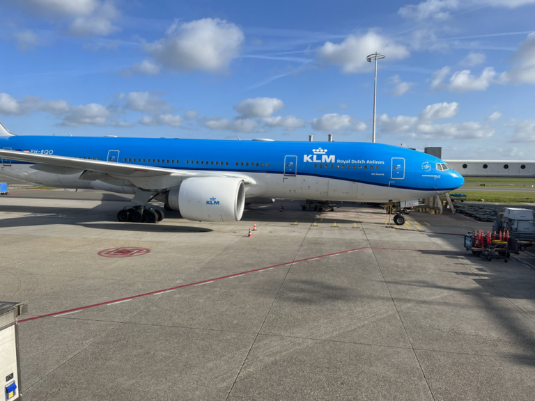a blue and white airplane on a tarmac
