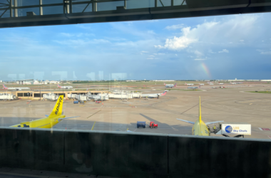 a view of airplanes at an airport from a window