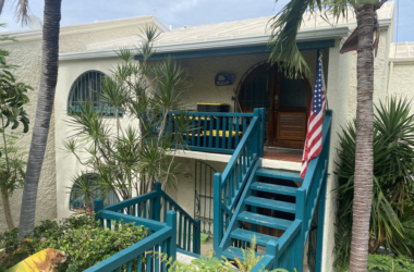 a house with blue railings and a flag