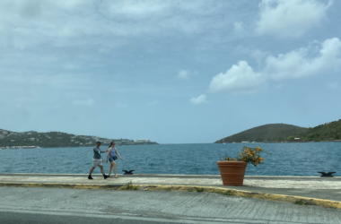 a man and woman walking on a sidewalk by water