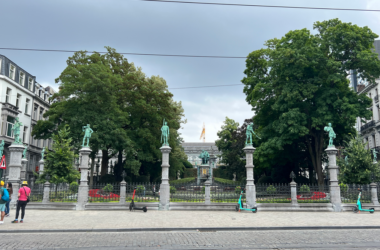 a group of statues on pillars in front of a building