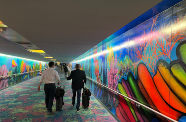 a group of people walking in a hallway with luggage