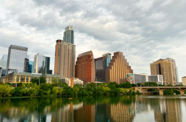 a city skyline with trees and a body of water