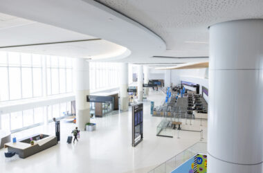 a large white building with people walking in it
