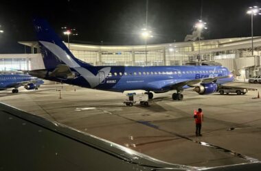 a blue airplane on a tarmac at night