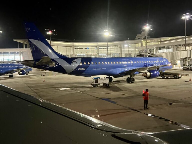 a blue airplane on a tarmac at night