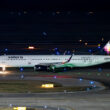 a white airplane on a runway at night