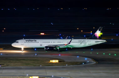 a white airplane on a runway at night