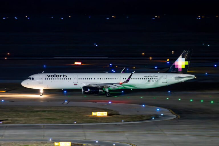 a white airplane on a runway at night