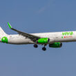 a white and green airplane flying in the sky