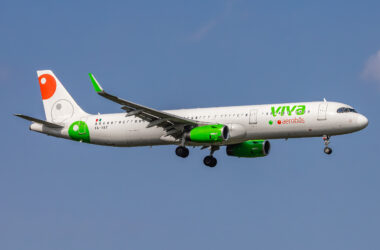 a white and green airplane flying in the sky