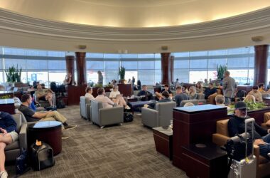 a group of people sitting in a room with large windows