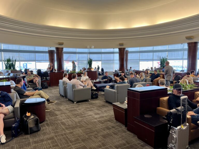 a group of people sitting in a room with large windows