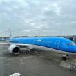 a blue and white airplane at an airport