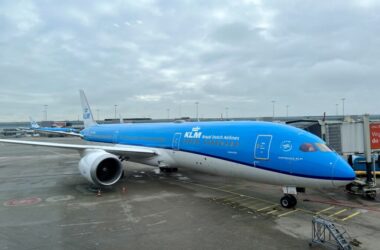 a blue and white airplane at an airport