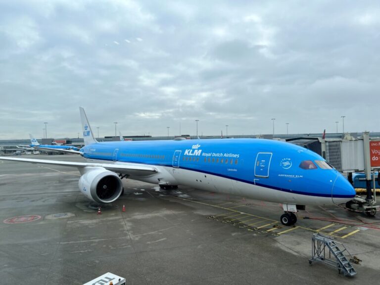 a blue and white airplane at an airport