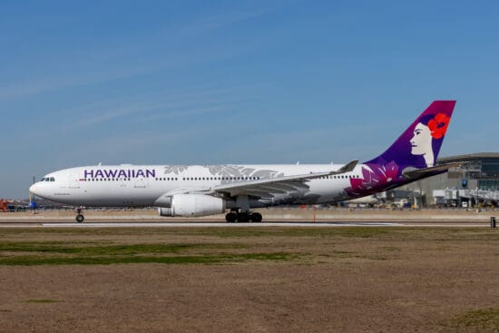 a white and purple airplane on a runway