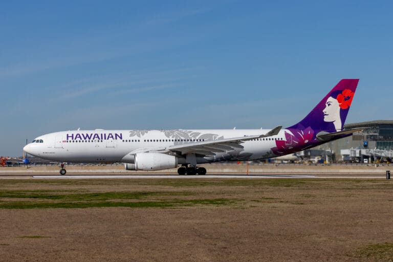 a white and purple airplane on a runway