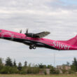 a pink airplane flying in the sky