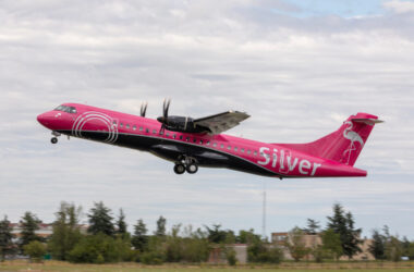 a pink airplane flying in the sky