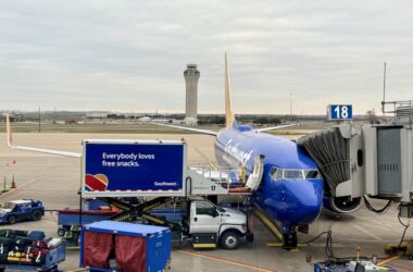 a blue airplane on a runway