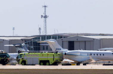 a green truck and plane on a runway