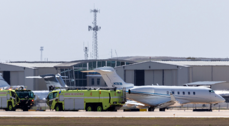 a green truck and plane on a runway