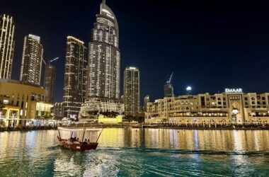 a boat in a body of water with buildings in the background