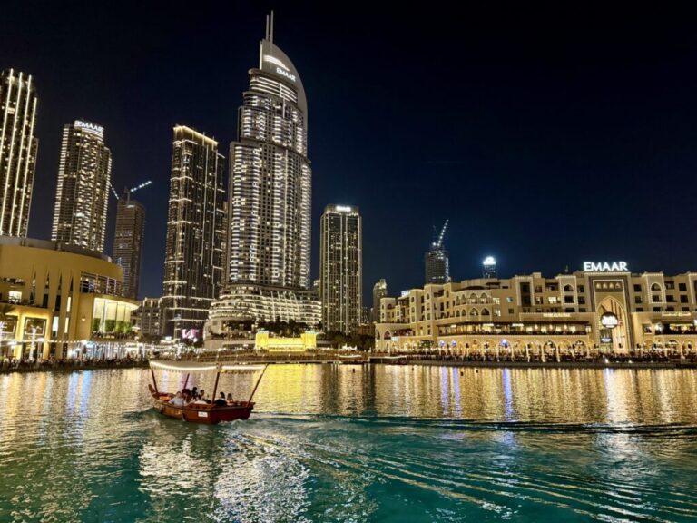 a boat in a body of water with buildings in the background