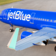 a blue airplane on a runway
