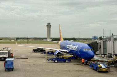 a blue airplane on a runway