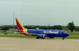 a blue airplane on a runway