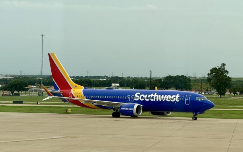 a blue airplane on a runway