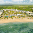 a resort with a pool and trees on the beach
