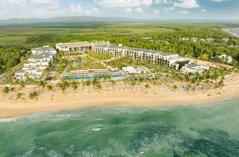 a resort with a pool and trees on the beach