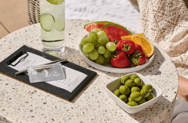 a plate of fruit and a glass of water next to a drink